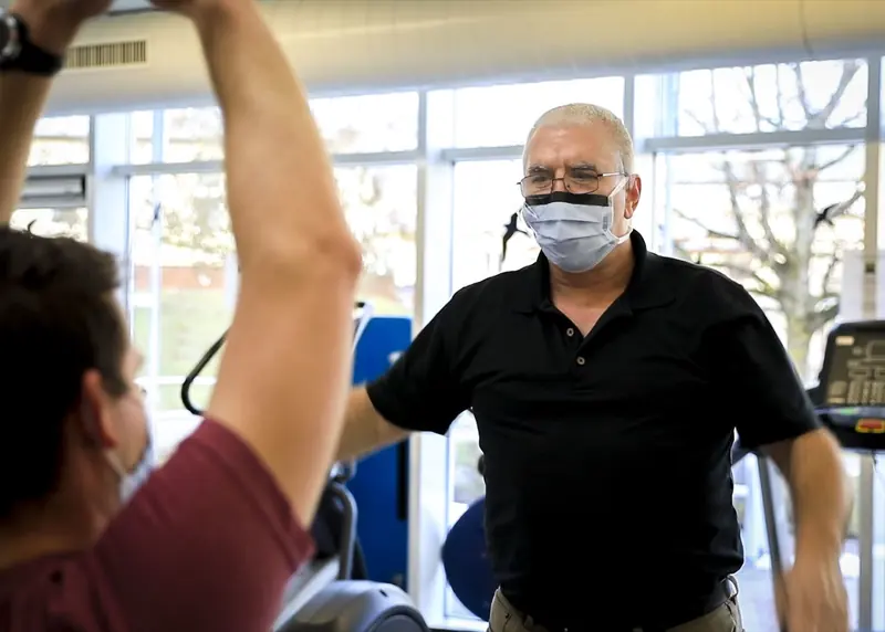 Fisioterapeuta avalia um paciente em uma sessão inicial
